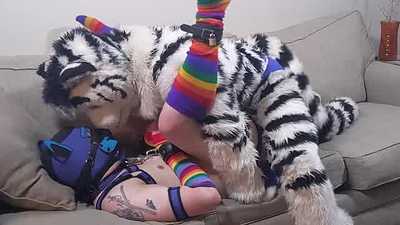 A tiger pinning a pup down